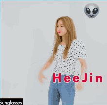 a woman wearing a polka dot shirt and jeans with the name hee jin written on the bottom