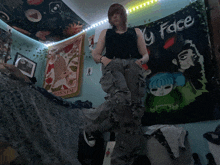 a girl stands in front of a wall with a tapestry that says my face