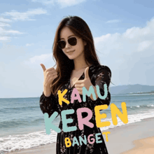 a woman giving a thumbs up on a beach with kamu keren banget written on the bottom