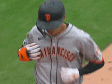 a baseball player for the san francisco giants wearing an orange adidas glove