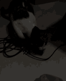 a cat is playing with a bunch of wires on the floor .