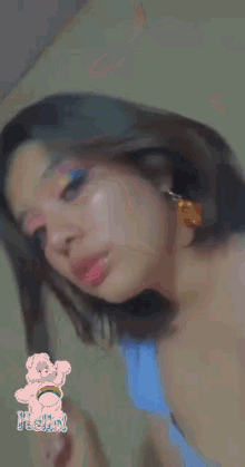 a close up of a woman 's face with a care bear sticker in the background