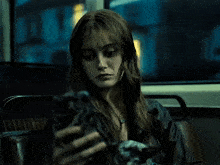 a woman is looking at her phone in the dark