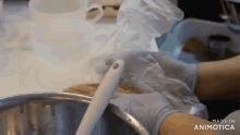 a person is holding a plastic bag over a bowl with a spoon .