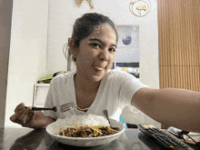 a woman sitting at a table eating a bowl of food