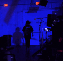 a red exit sign hangs from the ceiling of a dark room