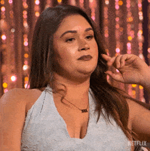 a woman wearing a white dress and a necklace with the word xxx on it