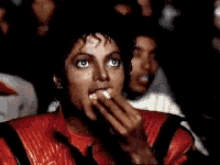 Michael Jackson eating popcorn, watching something entertained, exuding happiness