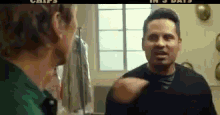 two men are standing next to each other and one is pointing at the other