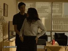 a man and a woman standing in a living room with the hashtag lialmeida05 on the bottom