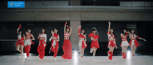 a group of women are dancing in front of a sign that says upfront