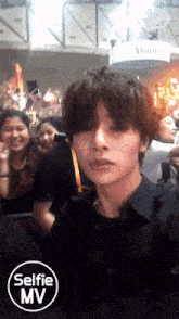 a man taking a selfie in front of a crowd
