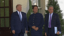 a man in a suit and tie stands next to another man in a suit and tie with a voa logo on the bottom left