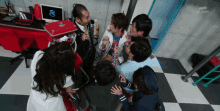 a group of people are gathered in a room with a tv asahi logo on the wall