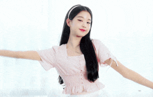 a girl with long black hair wearing a pink top