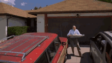 a man is standing in front of a house with the number 708