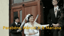 a bride and groom are standing in front of a church with the words parabéns marcio jr. & mariana behind them