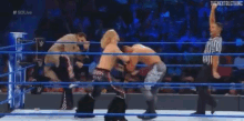 a wrestling match is being held in a ring with a referee .