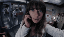 a woman is talking on a cell phone in a hospital room