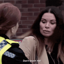 a woman is talking to a police officer who says " don 't touch me "