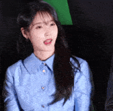 a woman wearing a blue shirt with buttons that say gucci on them