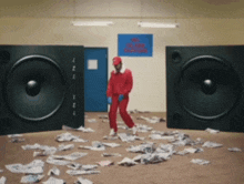 a man in a red jumpsuit is standing in front of a sign that says no smoking