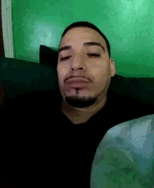 a man with a beard and mustache is laying on a bed with his eyes closed