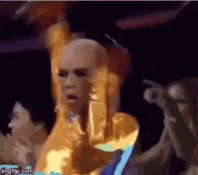 a pixelated image of a man in a gold costume dancing