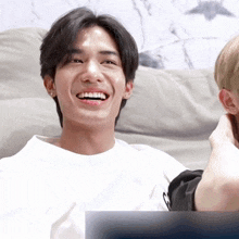 a man in a white shirt is laughing with another man