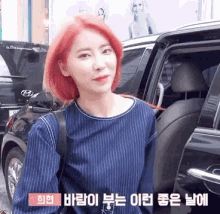 a woman with red hair is getting out of a car in a foreign language