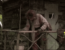 a man standing on a balcony holding a can of soda