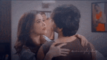 a man and a woman are hugging each other in a bedroom .