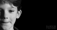 a close up of a young boy 's face with a black background .