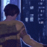 a woman in a yellow dress is looking out a window at night .