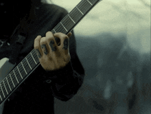 a person playing a guitar with a tattoo on their finger that says ' 666 '