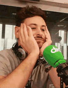 a man wearing headphones and a green microphone with the word dn on it