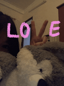 a girl giving a peace sign with the word love written above her