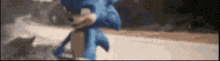 a blurry picture of a blue sonic the hedgehog running down a road .