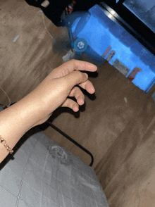a person 's hand reaches out towards a blue container