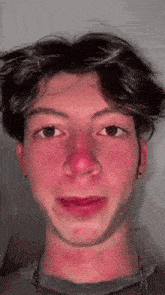 a close up of a young man 's face with red cheeks and a red nose .