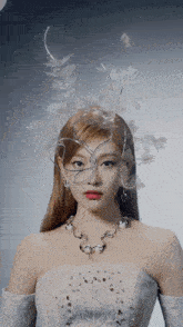 a woman wearing a white dress and a necklace has a wire crown on her head