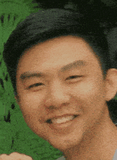 a close up of a young man 's face with a smile on his face