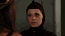 a woman in a batman costume is standing in front of a mirror .