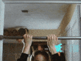 a woman hangs upside down on a bar in a doorway