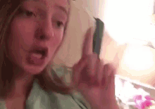 a woman is giving the middle finger to the camera while sticking her tongue out .