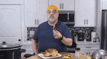 a man in a kitchen with a chicken on a plate