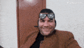 a man wearing sunglasses and headphones is smiling while taking a selfie .