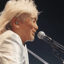 a man is singing into a microphone on a stage .