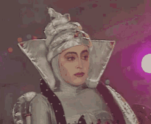 a woman in a silver costume with a very large hat
