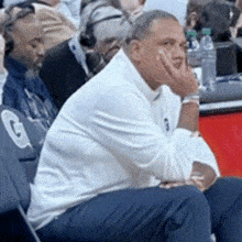 a man in a white shirt sits in a chair with a gatorade logo on it